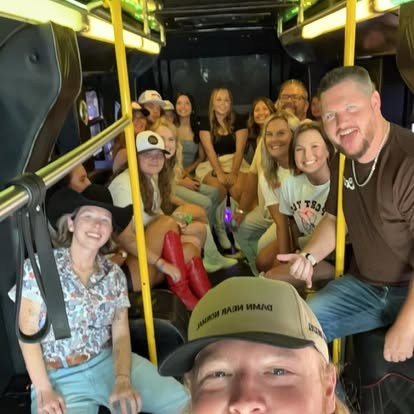 Nate beaming with a whole crew packed into a party bus.