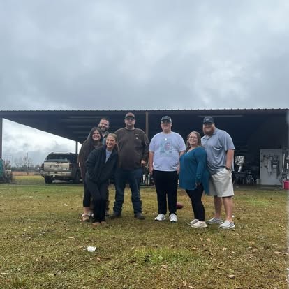 Nate and the whole crew smiling together under the barn.