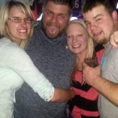 Laughing out loud, arms around friends on a night out.