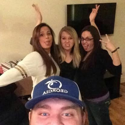 Goofy group selfie with friends throwing up peace signs.